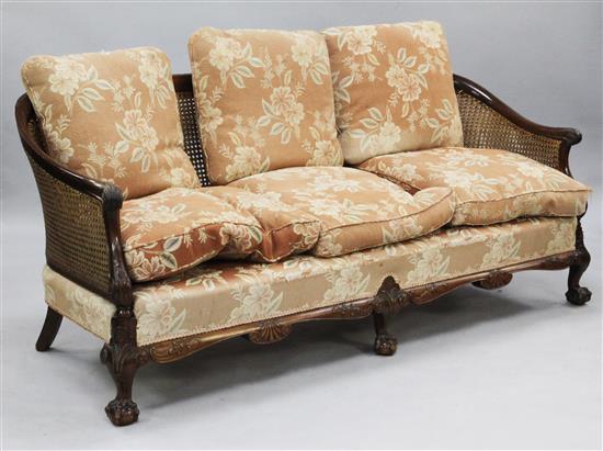 An early 20th century mahogany double caned bergere settee,